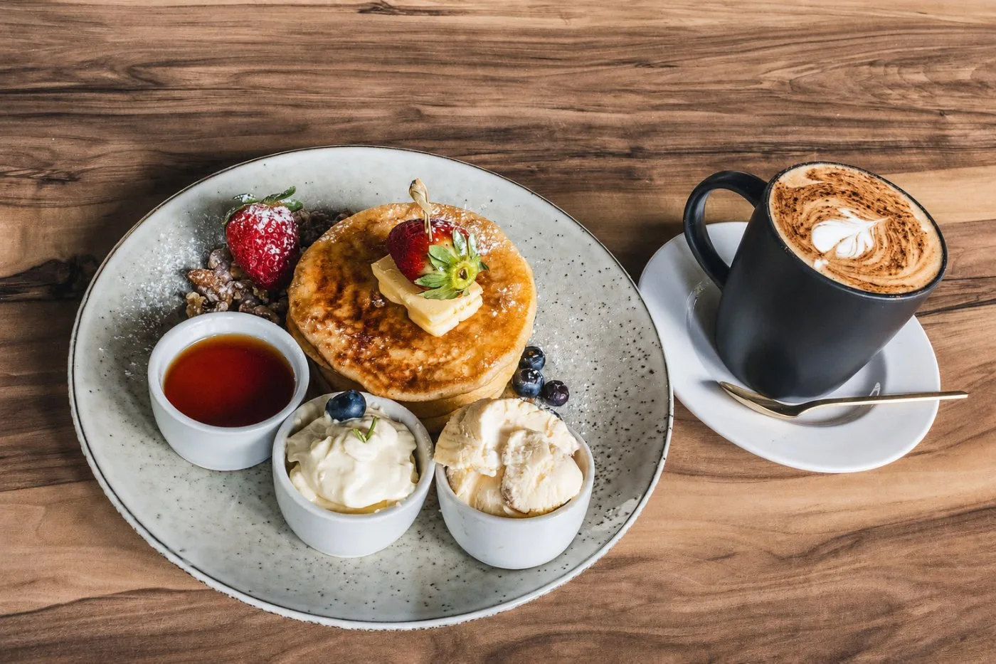 Pancakes with strawberries, cream and a latte for morning tea